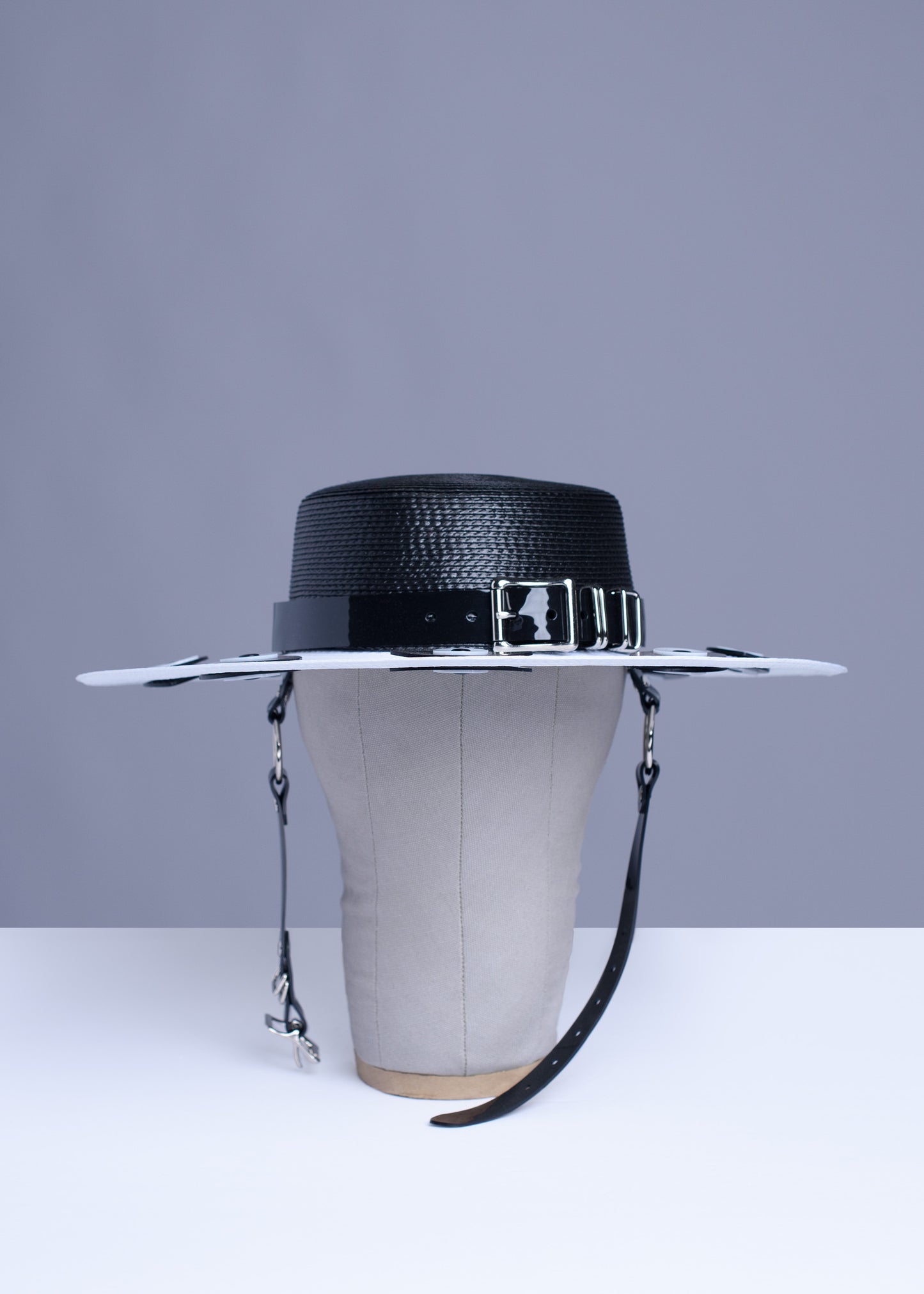 Apatico harness hat with wide brim. Black and white two-tone faux strap. Eyeball design all around the brim.