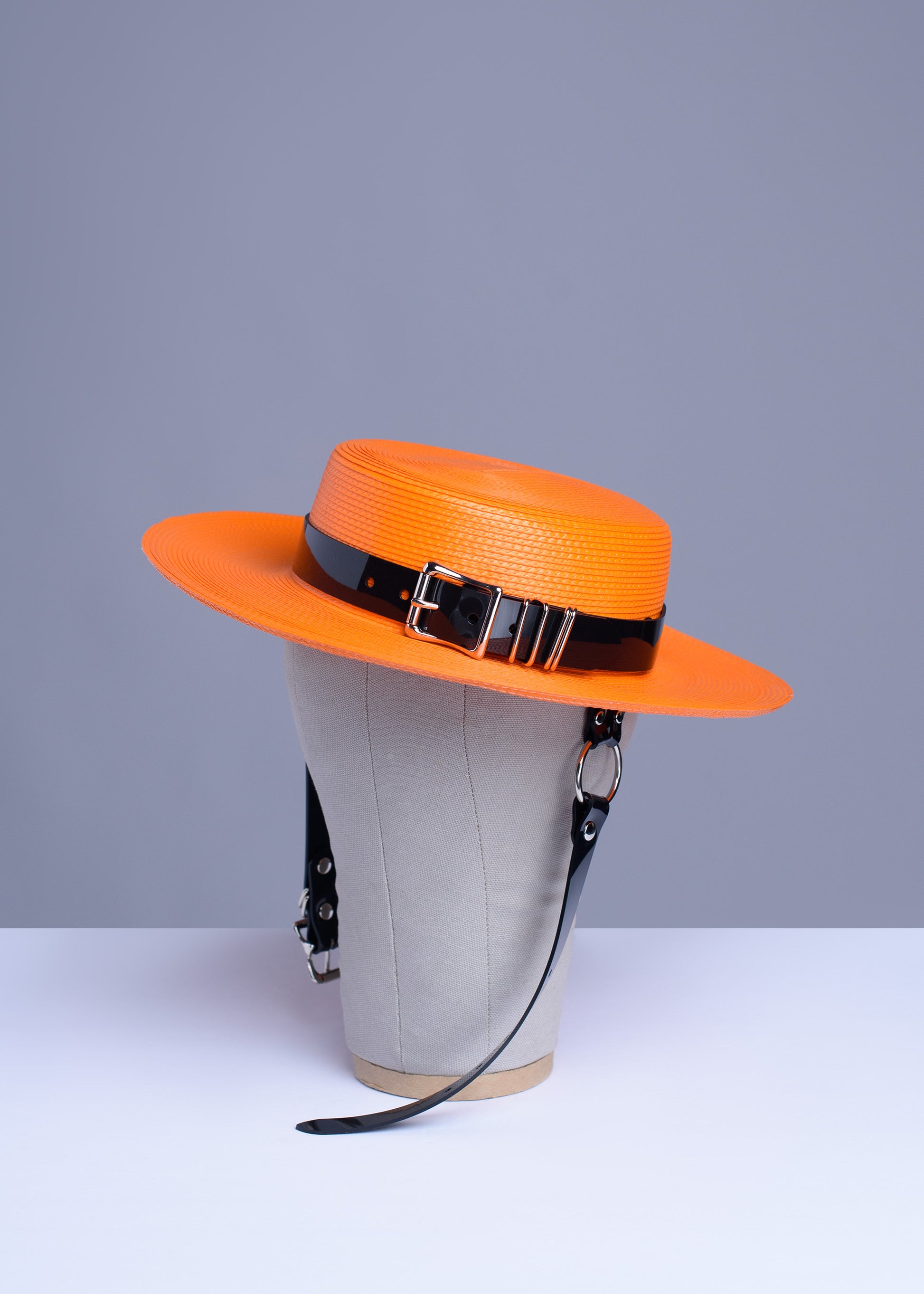 Apatico harness hat in orange with black pvc buckle band and harness chin straps, perfect spooky halloween vibes